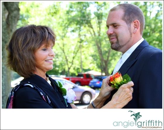 Mother of Groom putting boutonniere on groom